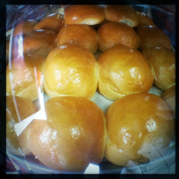 Image of a bunch of pork buns in a glass case.