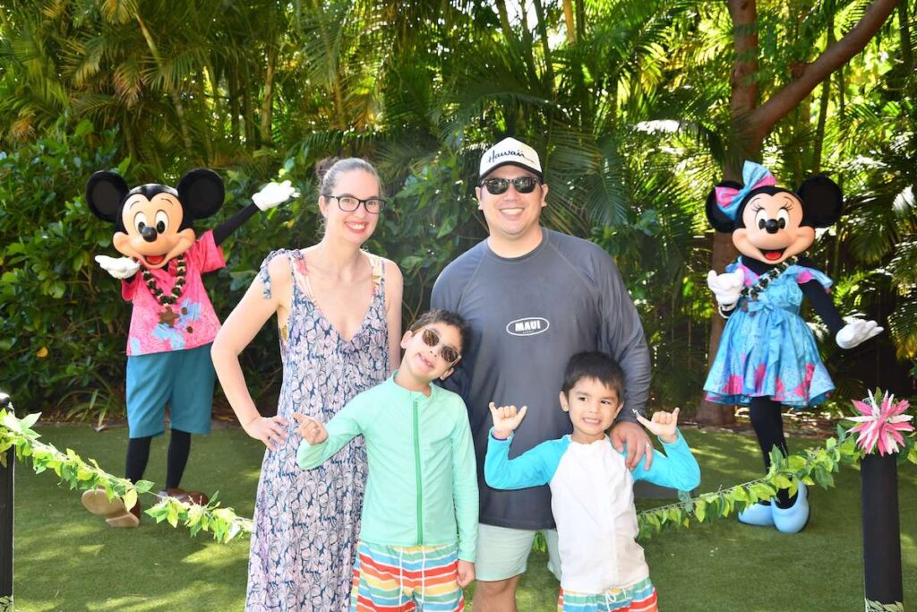 Image of a family posing with Mickey and Minnie Mouse in Hawaii at Disney Aulani Resort.