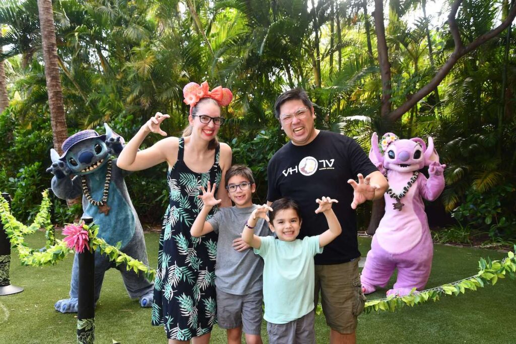 Image of a family making claws with their hands as they pose with Stitch and Angel at Disney Aulani Resort in Hawaii.