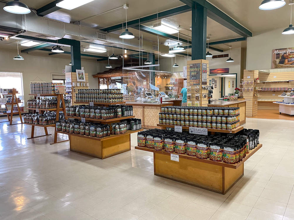 Image of the interior of a macadamia nut factory gift shop featuring shelves of mac nut products.