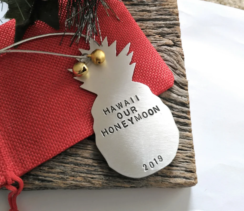 Image of a metal pineapple ornament with the words Hawaii Our Honeymoon 2019 etched in it.