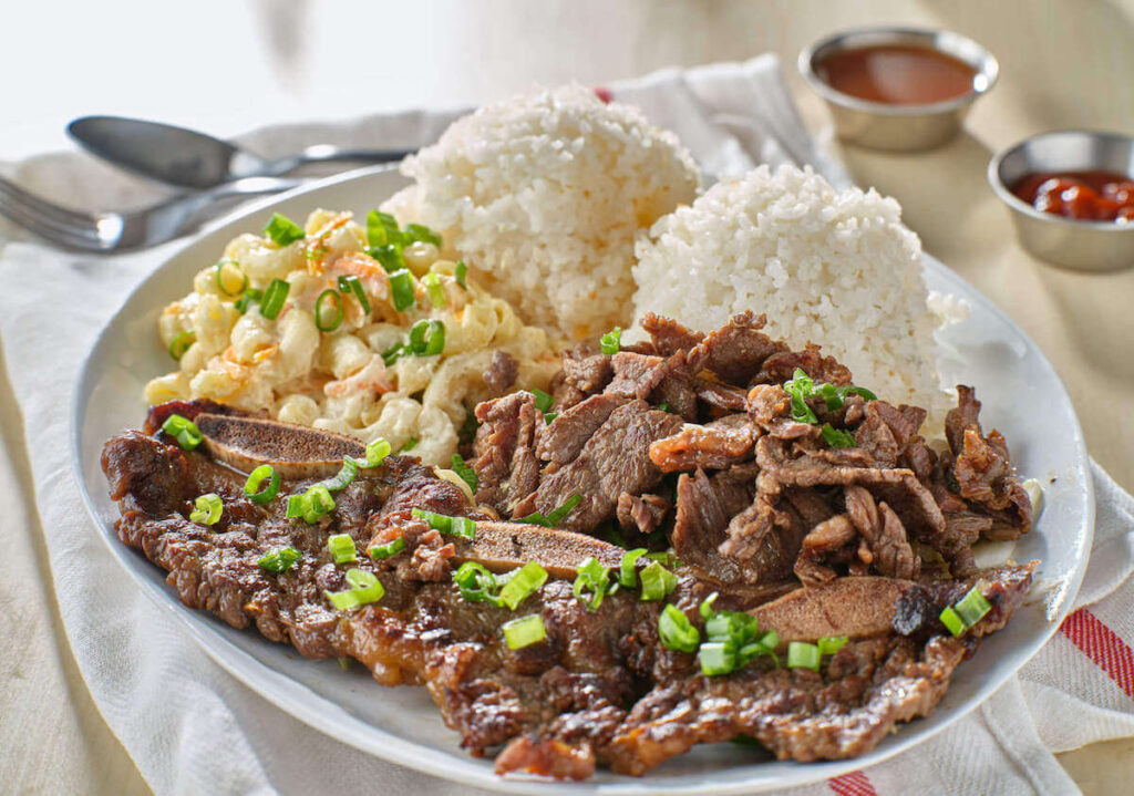 Image of kalbi ribs, macaroni salad, and two scoops of white rice on a plate.