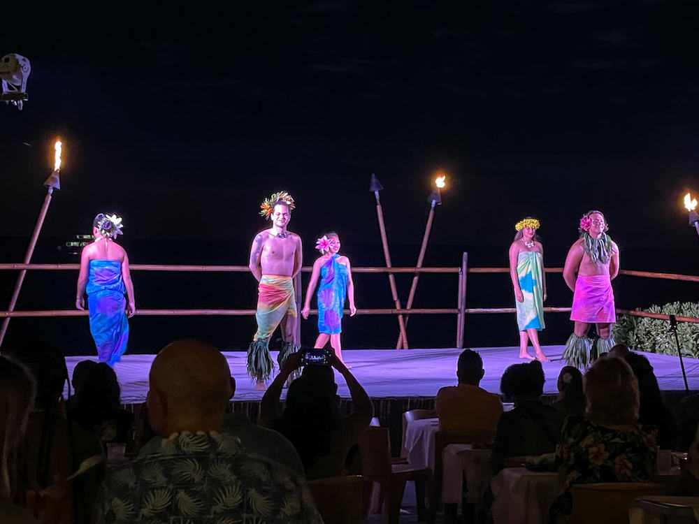 Image of 5 people on stage wearing a pareo in different ways at this Big Island luau.