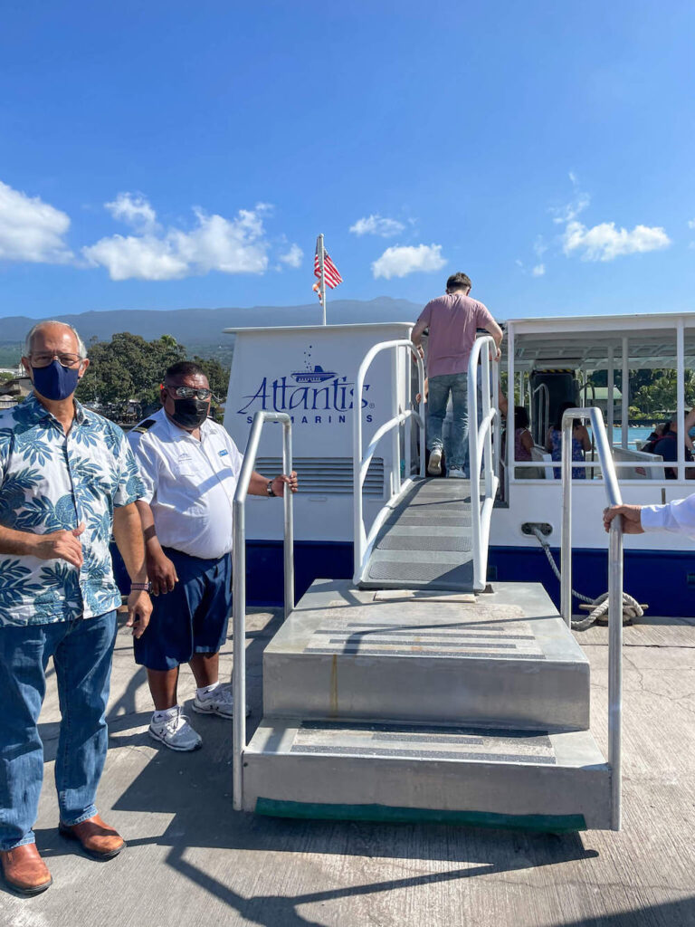 Image of crew members welcoming us as we step aboard the shuttle boat for Atlantis Submarines in Hawaii.