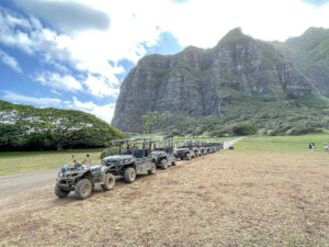 Read this honest Kualoa Ranch ATV tour review by top Hawaii blog Hawaii Travel with Kids. Image of a line of ATVs and UTVs at Kualoa Ranch in Hawaii