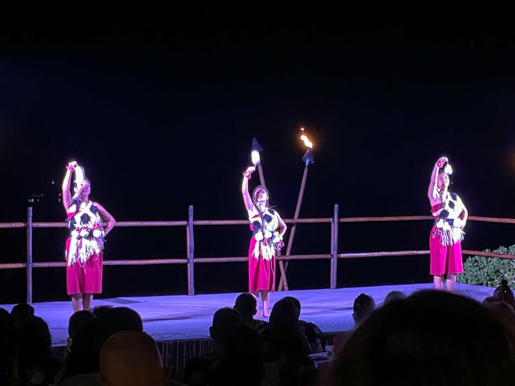 Image of women on stage dancing with short poi balls.