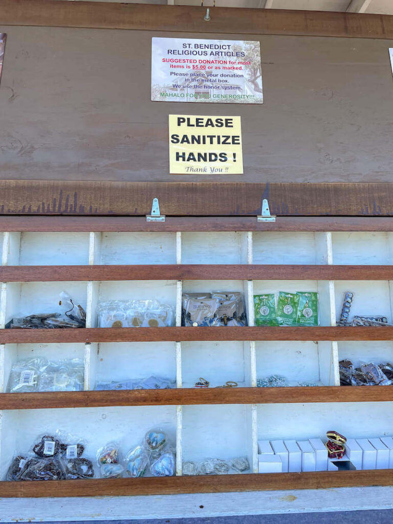 Image of a shelf with lots of religious items to buy as souvenirs at the Painted Church in Hawaii.