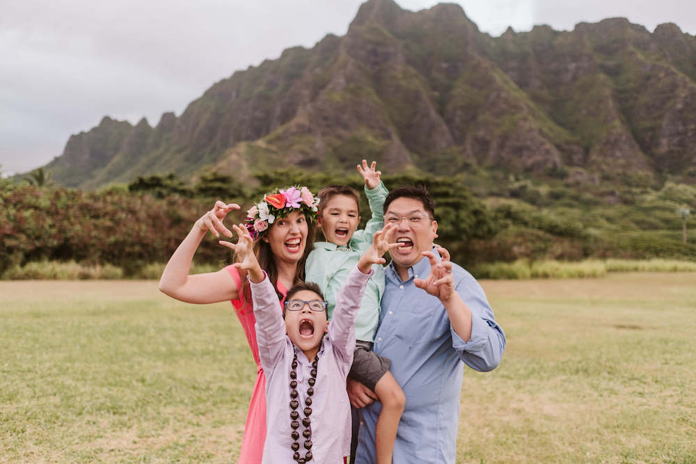 Image of a family pretending to be dinosaurs at Kualoa Beach Park on Oahu