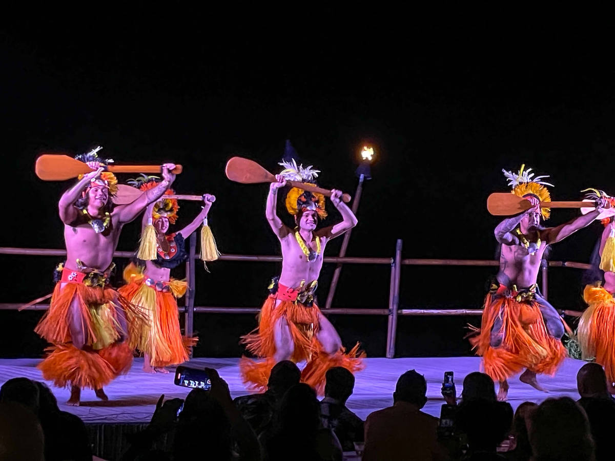 Check out this honest review of the Royal Kona Luau on the Big Island by top Hawaii blog Hawaii Travel with Kids. Image of male and female Tahitian dancers on stage at night.