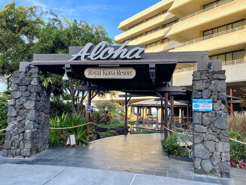 Image of a large sign that says Aloha with stone pillars on each side.