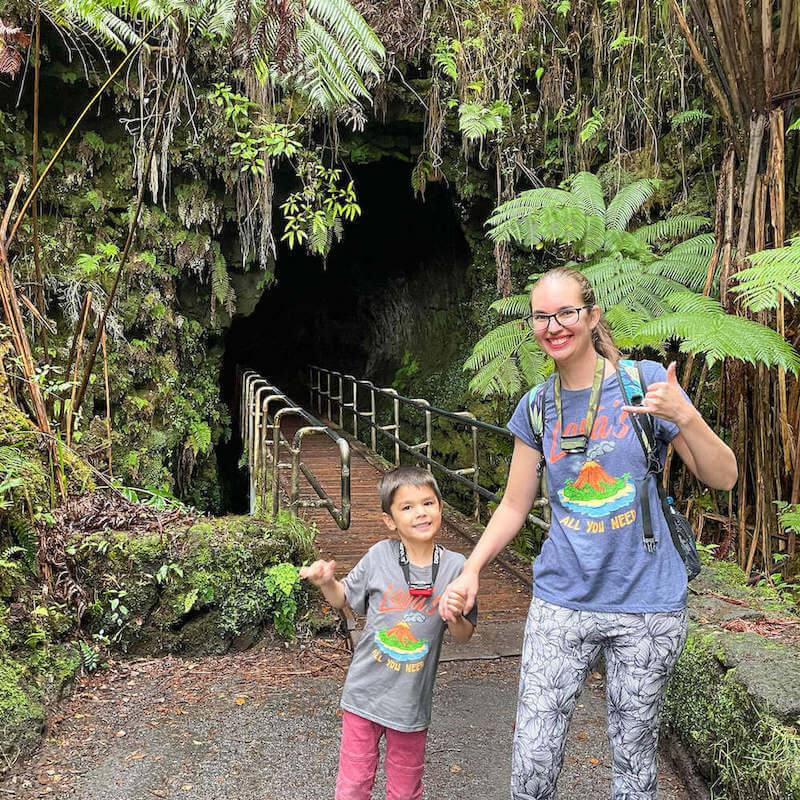 Image of a mom and son posing in front of a lava tube in Hawaii