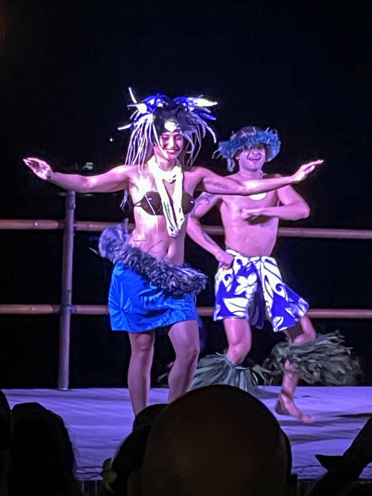 Image of a man and woman wearing blue costumes dancing on stage.