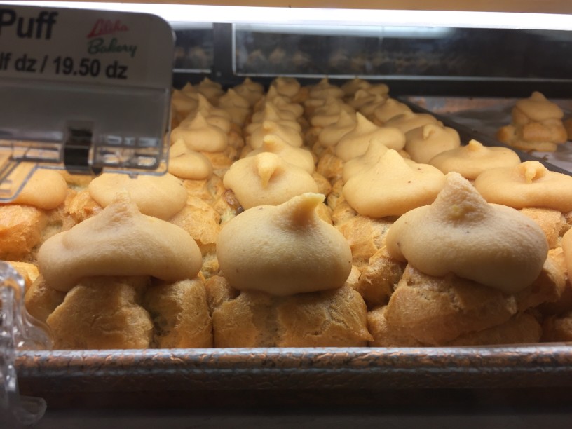 Image of a bakery case filled with pastries topped with coco frosting.