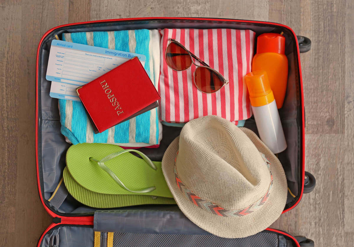 Find out what to add to your Big Island packing list by top Hawaii blog Hawaii Travel with Kids. Image of a suitcase with brightly colored items inside.