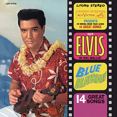 Image of Elvis Presley wearing a lei and an Aloha shirt while playing the ukulele.