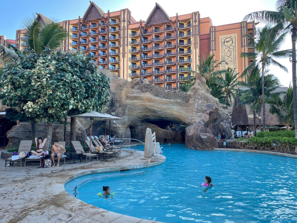 Image of a swimming pool with a hotel tower in the background.