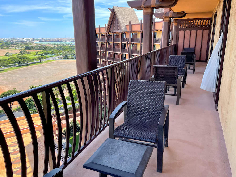 Image of a super long lanai with 3 sets of tables and chairs.