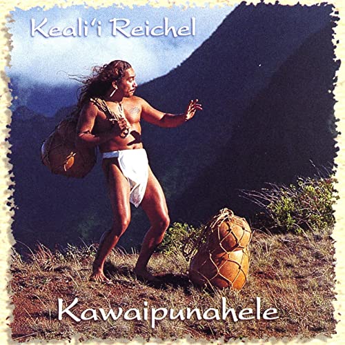 Image of Keali'i Reichel standing on a mountain holding gourds.