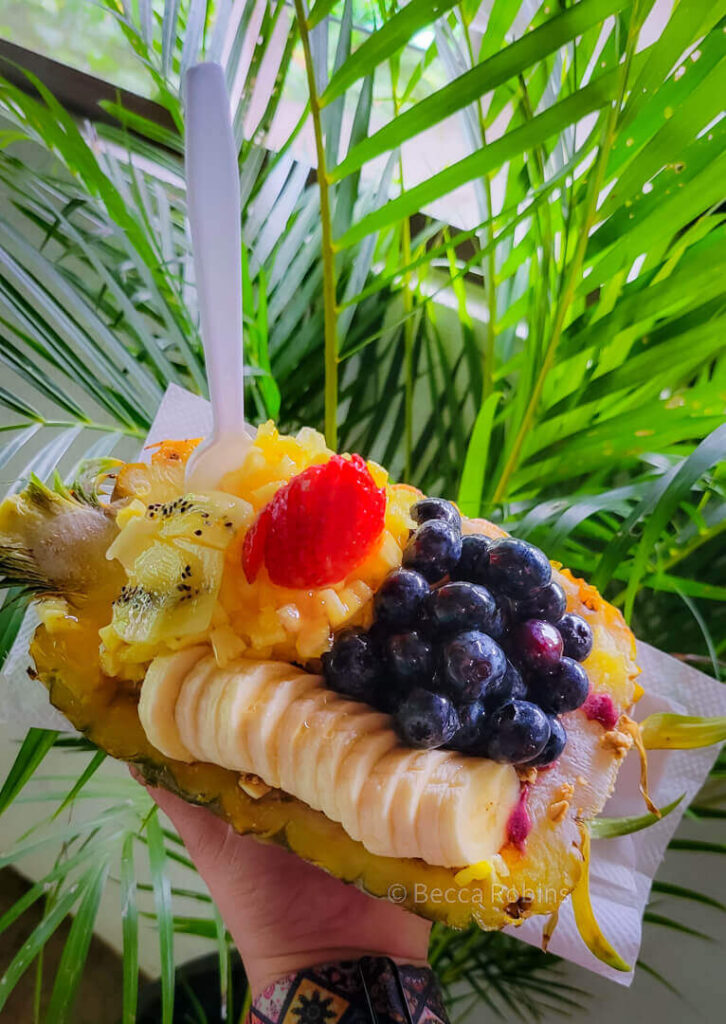 Image of a gorgeous fruit plate on top of a halved pineapple.