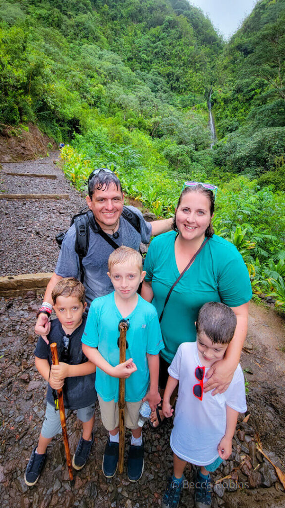 Image of a family of five posing with Manoa Falls in the background