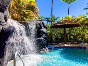 Check out this honest Marriott Maui Ocean Club review to see if it's one of the best places to stay on Maui with kids. Image of a waterfall going into a swimming pool on Maui.