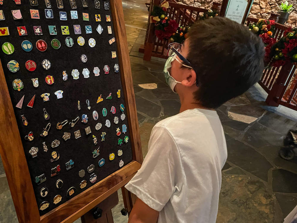 Image of a boy choosing pins to trade at Disney Aulani resort in Hawaii.