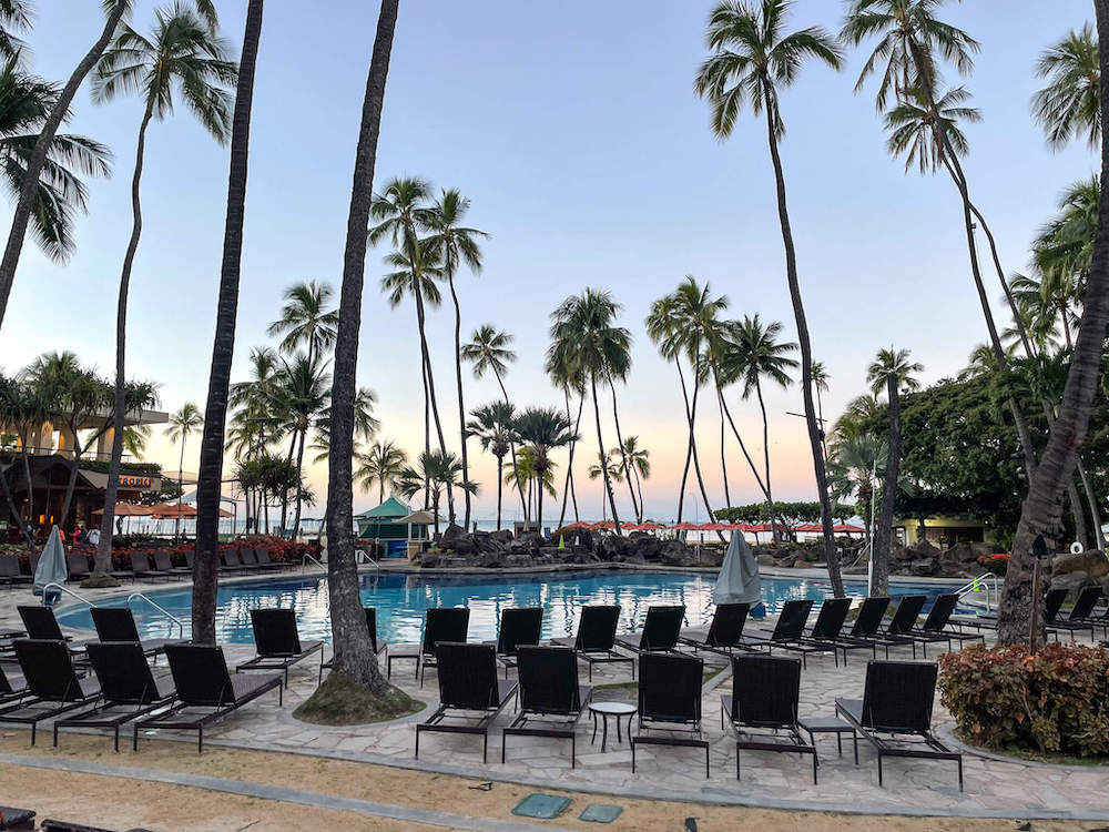 Image of an empty pool at sunrise at the Hilton Hawaiian Village Resort in Waikiki.