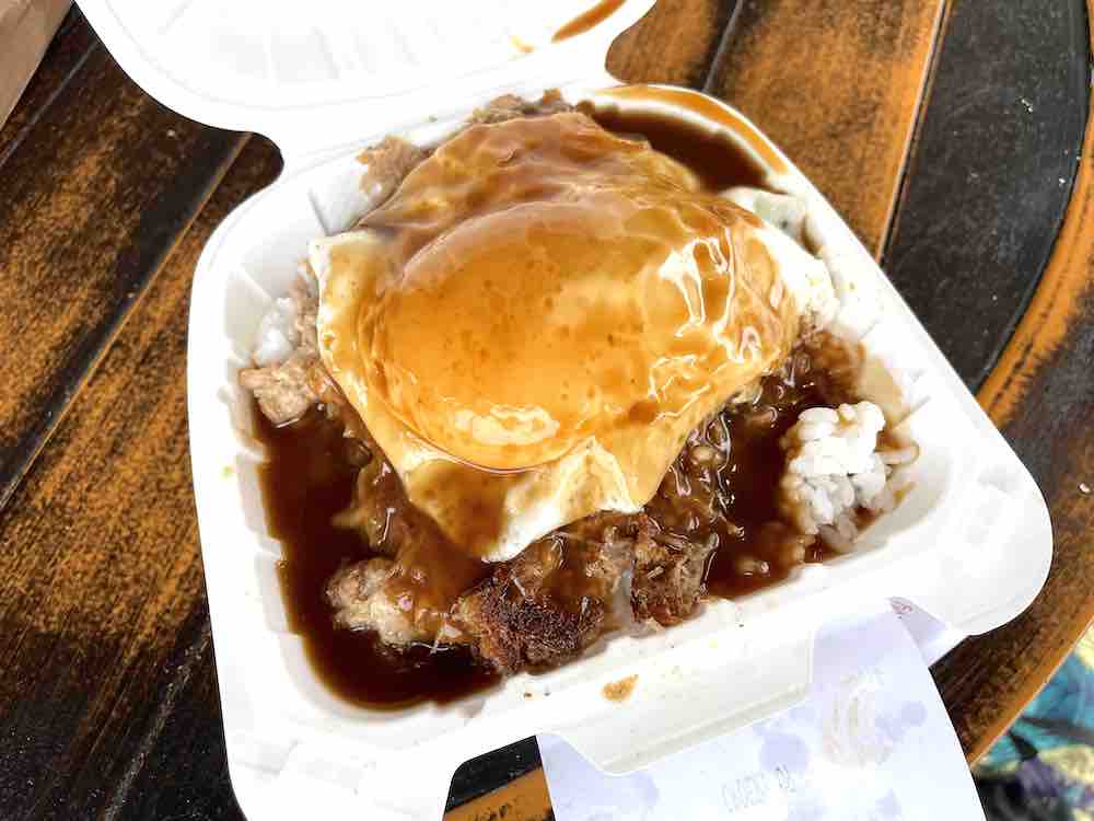 Image of a takeout container with rice, hamburger patty, fried egg, and gravy