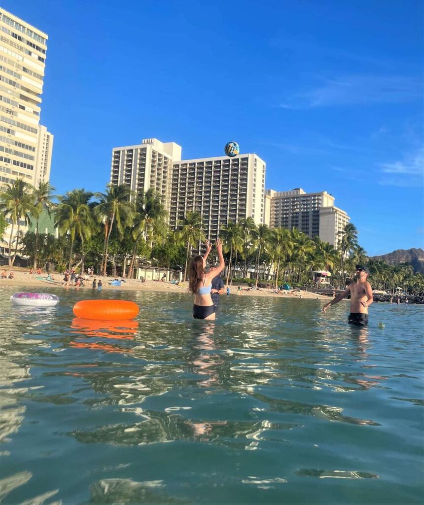 Image of people playing in the ocean at Waikiki Beach in front of the Hyatt Regency Waikiki Beach.