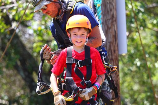 Image of a boy wearing a red shirt getting ready to go ziplining on Maui.