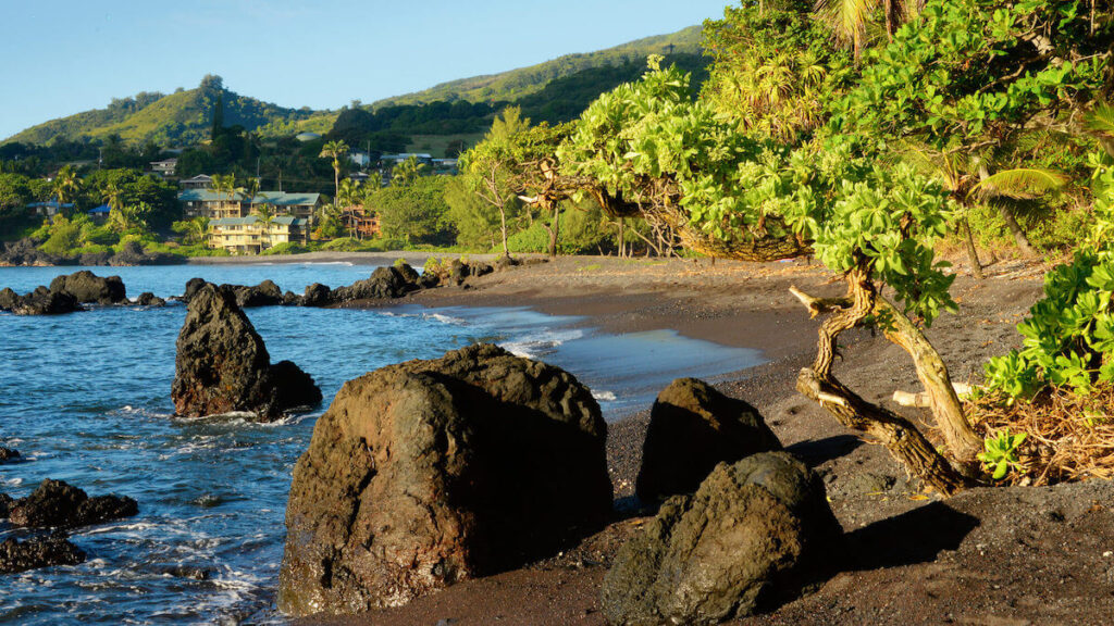 Image of Hana Bay with rocks and a hotel in the background.