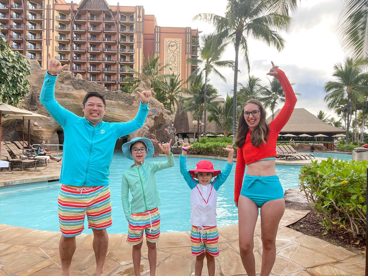 Check out this adorable Family Matching Sun Protection Swimwear for Hawaii recommended by top Hawaii blog Hawaii Travel with Kids. Image of a family wearing rainbow printed matching bathing suits in Hawaii.
