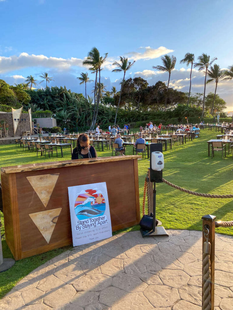 Image of a woman standing behind a check in desk at a luau in Wailea Maui.