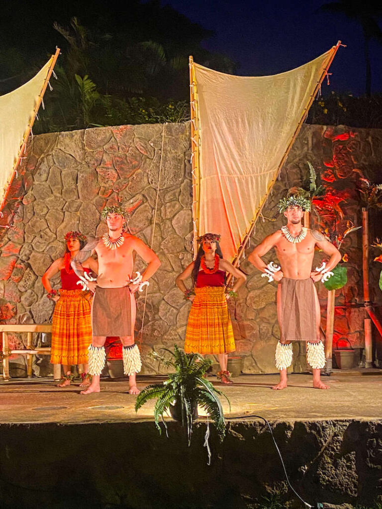 Image of male and female dancers in traditional Hawaiian hula costumes on stage at a luau on Maui.