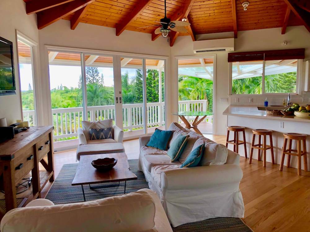 Image of a white couch and chairs in a living room at a Hana Maui rental home.