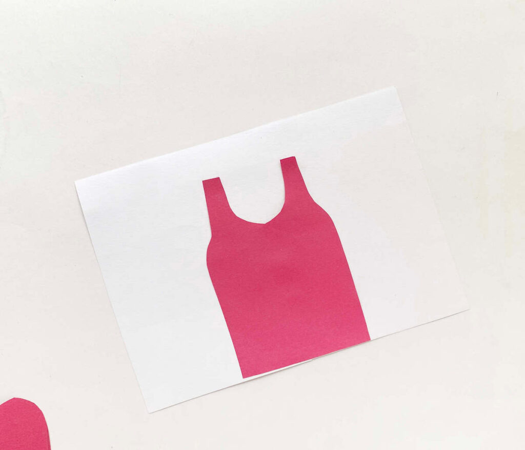 Image of a white piece of paper with a little pink dress printed on it.
