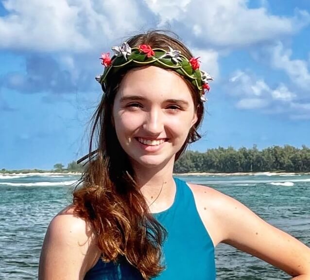 Image of a girl smiling at the camera while wearing a flower crown.