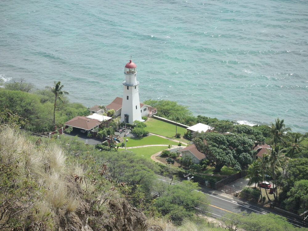 Image of a lighthouse and homes on the ocean.