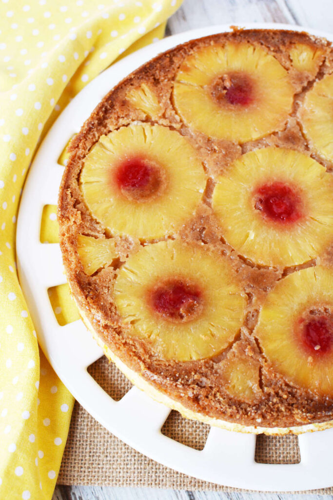 Image of a cake with pineapple rings and cherries on it.