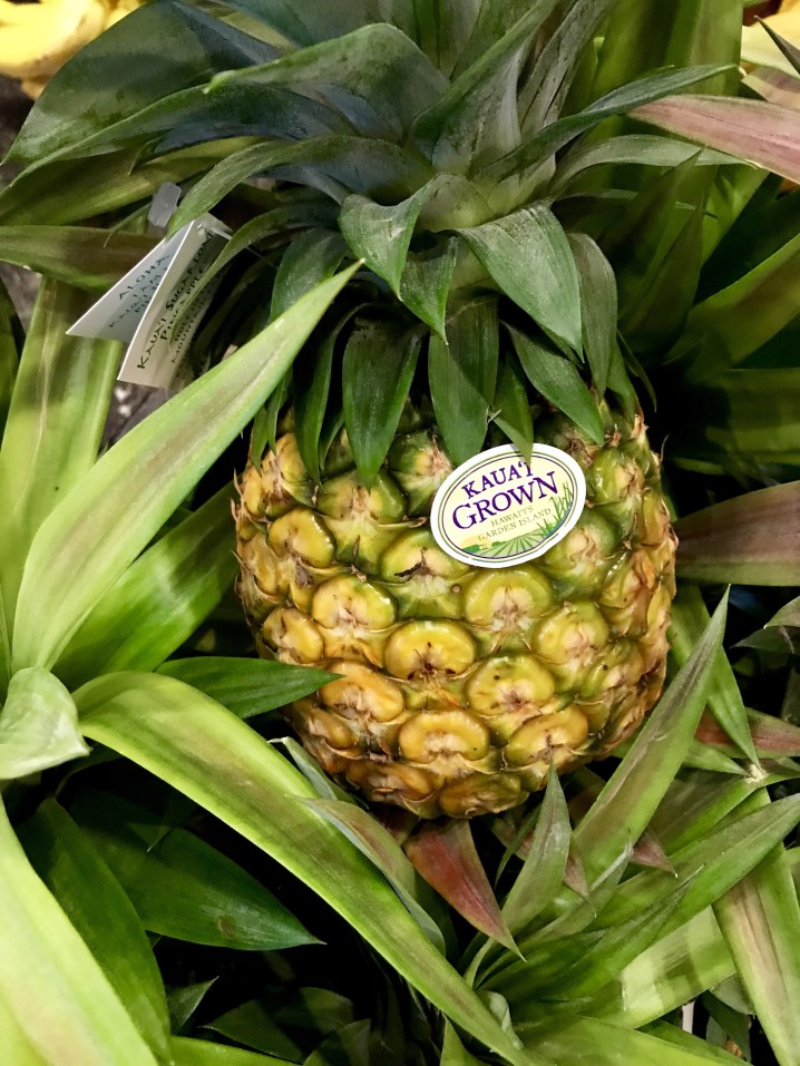 Image of a Kauai grown sugarloaf pineapple in a box.