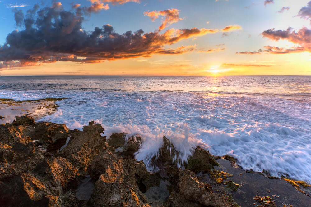 Image of sunset on a rocky beach on Oahu