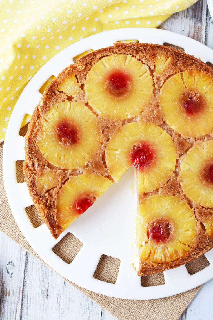 Learn how to make this easy pineapple upside down cheesecake recipe by top Hawaii blog Hawaii Travel with Kids! Image of a pineapple upside down cake with a slice missing.