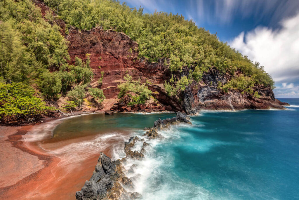 Find out the best things to do in Hana Maui by top Hawaii blog Hawaii Travel with Kids. Image of a red sand beach in Hana Maui.