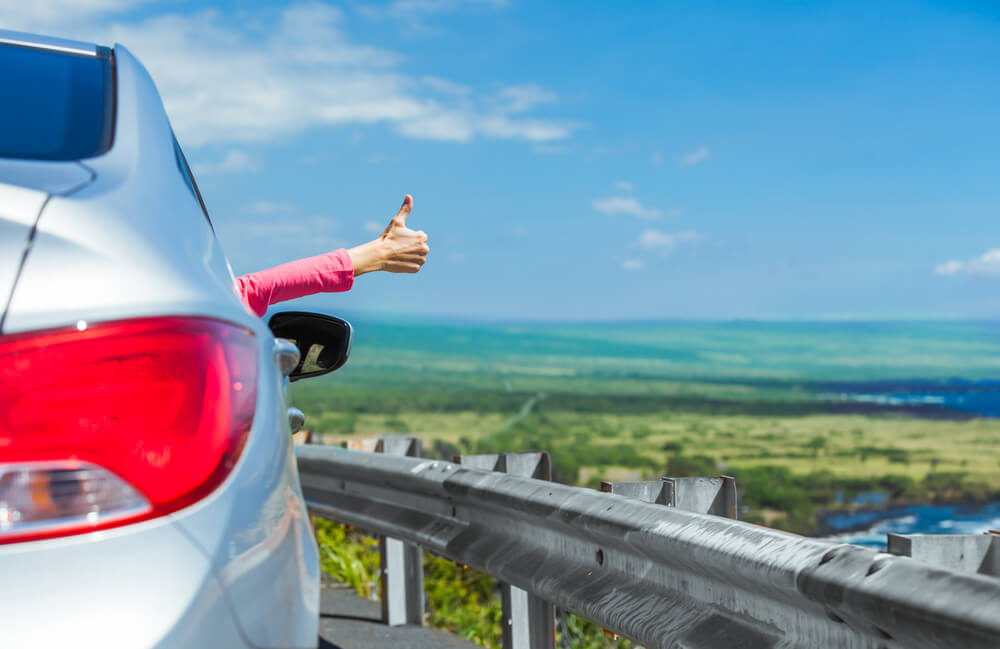 Image of someone giving a thumbs up out he window of a car on Oahu
