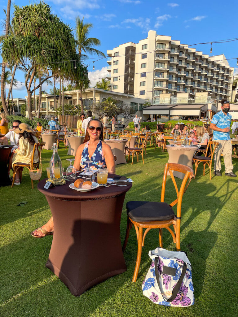 Image of a woman sitting at a table at the outdoor Feast at Mokapu in Wailea Maui.