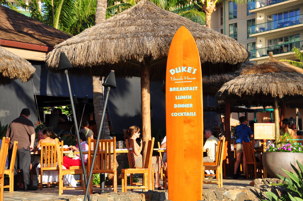 Image of the Duke's Beach House sign (it's a surfboard) and the restaurant.