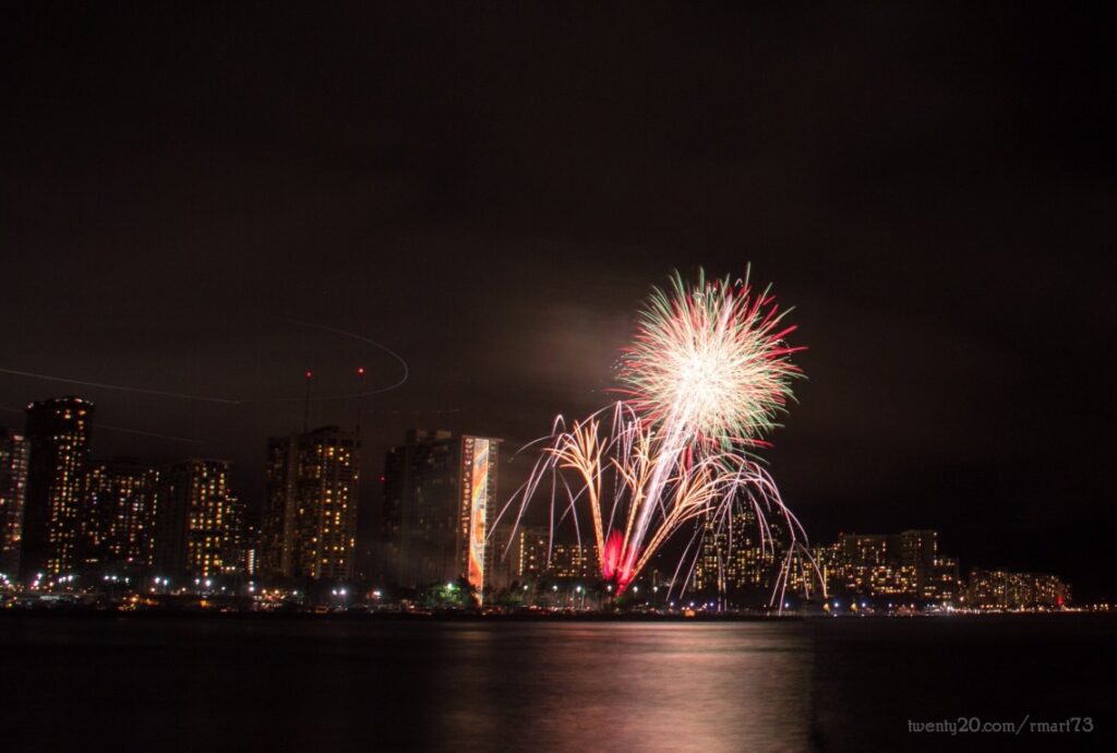 Image of fireworks going off over Waikiki at night.