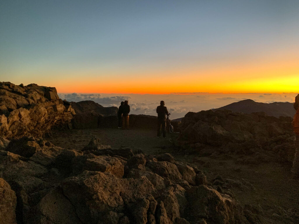 Image of a handful of people enjoying a Maui sunrise at Haleakala National Park.