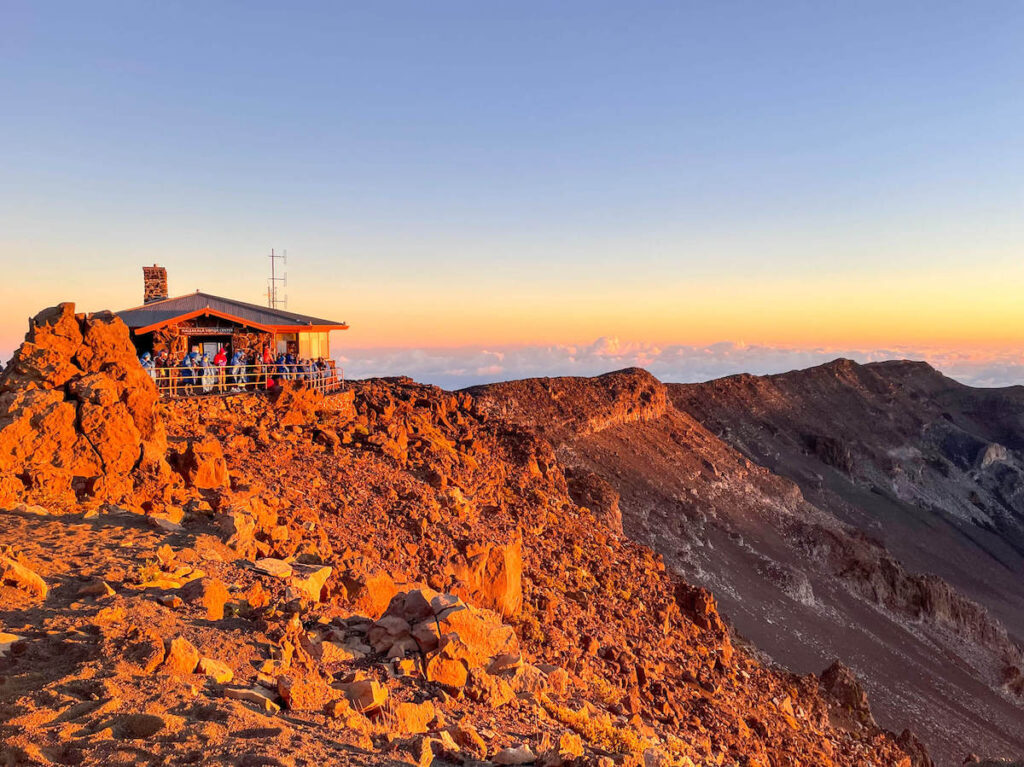 Check out this honest Haleakala Sunrise Tour Review by top Hawaii blog Hawaii Travel with Kids. Image of the Haleakala Visitor's Center at sunrise.