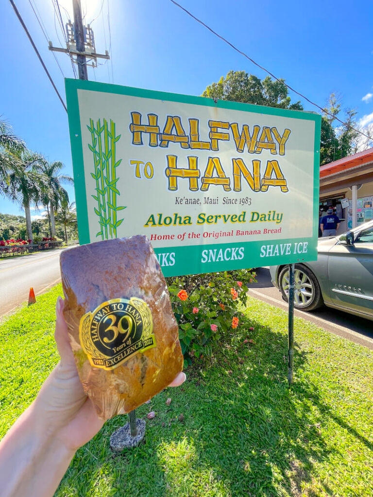 Image of a plastic wrapped loaf of banana bread in front of the Halfway to Hana stand on Maui.